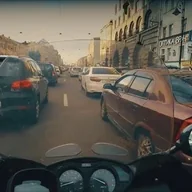 Вид с мотоцикла на плотную городскую пробку между рядами машин